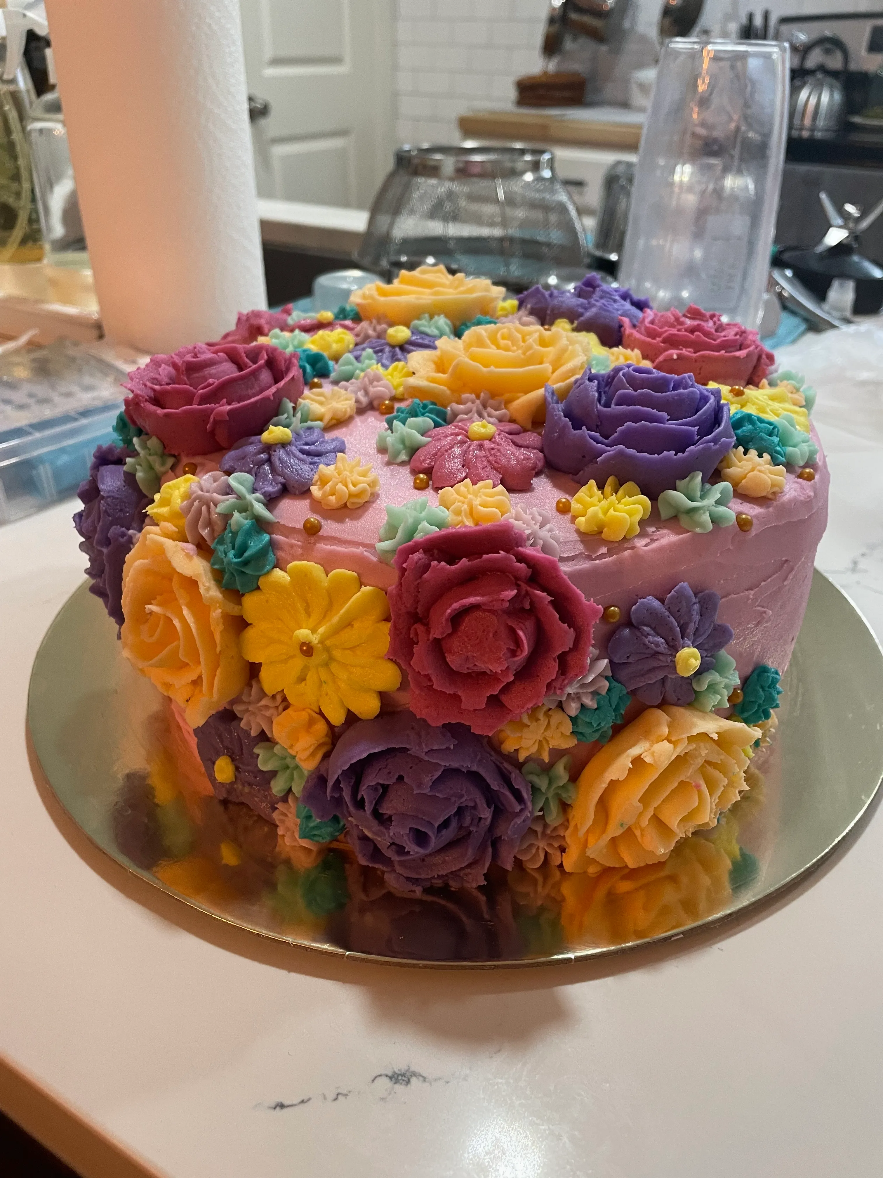 Colorful birthday cake covered in buttercream flowers